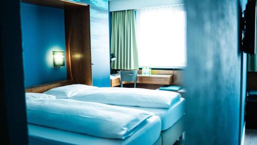 two beds in a hotel room with blue walls at Boutique Hotel Kronenhof in Zurich