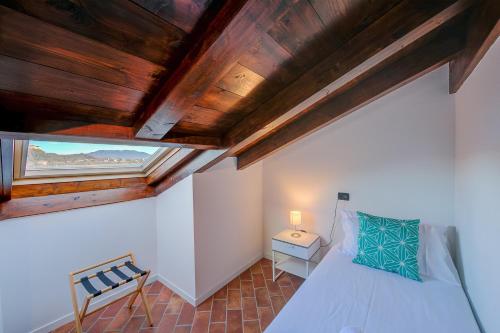 a bedroom with a bed and a wooden ceiling at Aparthotel Arona in Arona