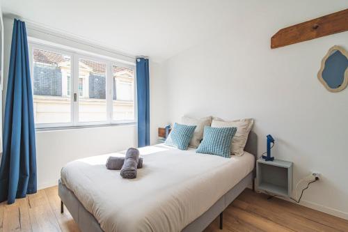 une chambre avec un grand lit avec des rideaux bleus dans l'établissement Le Seventies - Exceptionnel 4 chambres & billard, à Reims