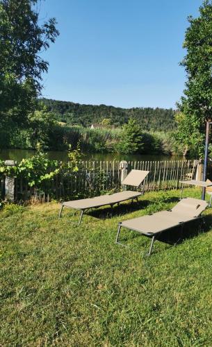 two picnic tables in the grass near a fence at s´Paradies Ferienwohnung in Beilngries