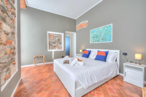 a bedroom with a white bed with blue and orange pillows at Aparthotel Arona in Arona