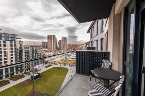 a balcony with a table and chairs and a view of a city at Belgrade Waterfront Residences - Beograd na vodi in Belgrade