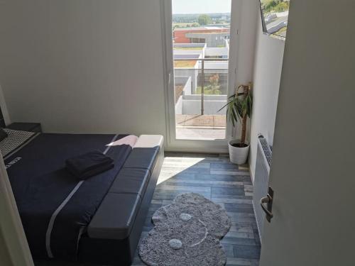 Cette petite chambre comprend un lit et un balcon. dans l'établissement Appartement près de Versailles - magnifique vue, à Fontenay-le-Fleury