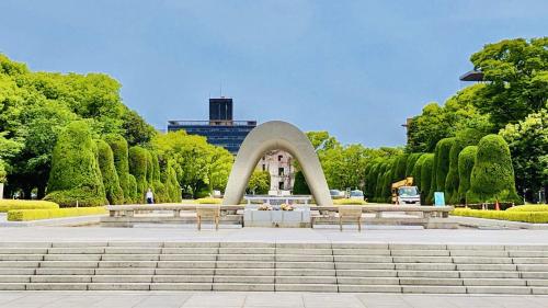 a fountain in a park with benches and trees at Toyoko Inn Hiroshima Ekimae Ohashi Minami in Hiroshima