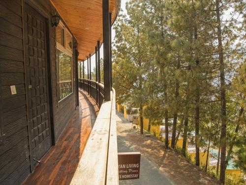 a building with a bench on the side of it at THEHIMALAYANLIVING WHISTLING PINES in Mukteswar