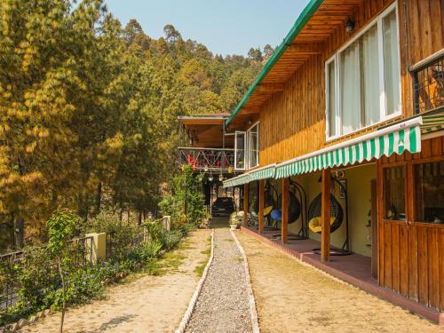 un camino de tierra delante de un edificio en THEHIMALAYANLIVING WHISTLING PINES en Mukteswar