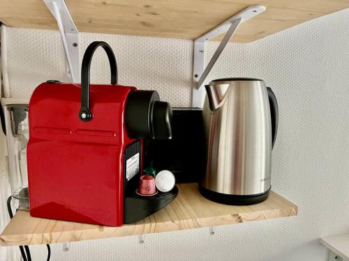 a red suitcase sitting on a shelf with a coffee pot at «Studio 2» rue Huchette - DABNB in Limoges