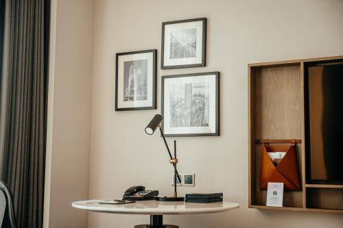 a room with a table with a lamp and pictures on the wall at Sheraton Guangzhou Hotel in Guangzhou