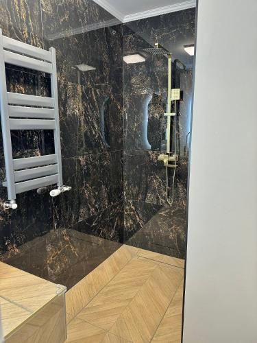 uma casa de banho com chuveiro e paredes em mármore preto em Luxury RA Apartment em Oradea