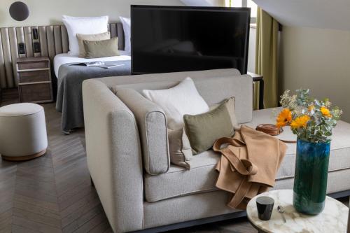 Hotel D Geneva في جنيف: غرفة معيشة مع أريكة وسرير