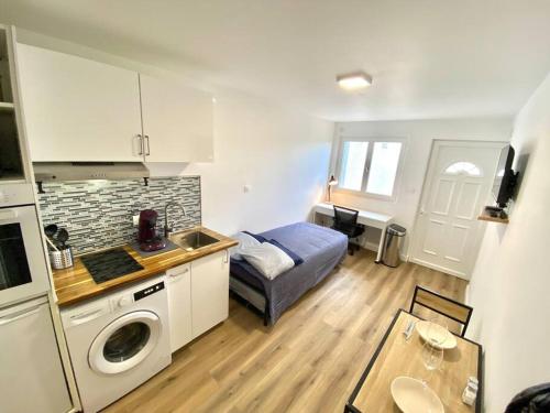 eine kleine Küche mit einem Bett und einem Waschbecken in einem Zimmer in der Unterkunft Cosy Studio neuf centre-ville in Orsay