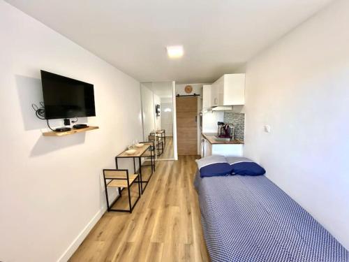 ein Zimmer mit einem Bett in der Mitte eines Zimmers in der Unterkunft Cosy Studio neuf centre-ville in Orsay