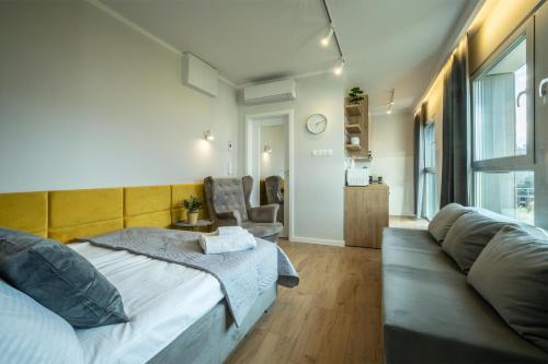 a bedroom with a bed and a couch at WiguryTower Apartaments 98 in Łódź
