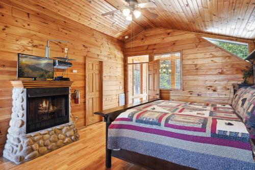a bedroom with a fireplace in a log cabin at Emerald City Lights #203 in Gatlinburg