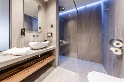 a bathroom with a sink and a shower at Hotel Eccher 3 stelle Superior in Mezzana