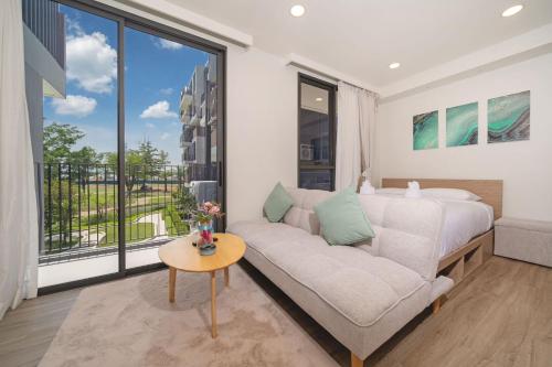 a living room with a couch and a bed and a window at Skypark Laguna BangTao Beach Apartment-Long Term Lease in Phuket Town