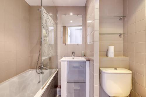 a bathroom with a toilet and a sink and a tub at Duplex T3, terrasse 18m2 vue mer, proche plage in Le Lavandou