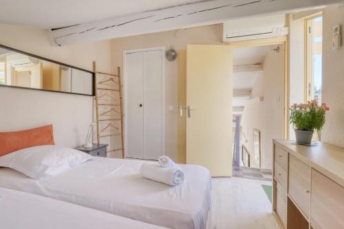 a bedroom with a bed with a towel on it at Duplex T3, terrasse 18m2 vue mer, proche plage in Le Lavandou