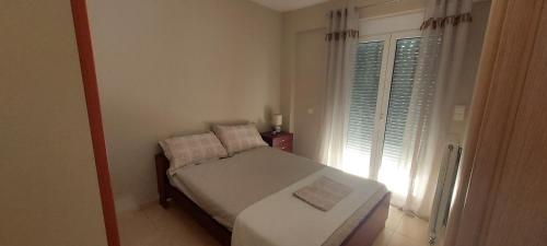 ein kleines Schlafzimmer mit einem Bett und einem Fenster in der Unterkunft Momenti Felici 2 in Artemida