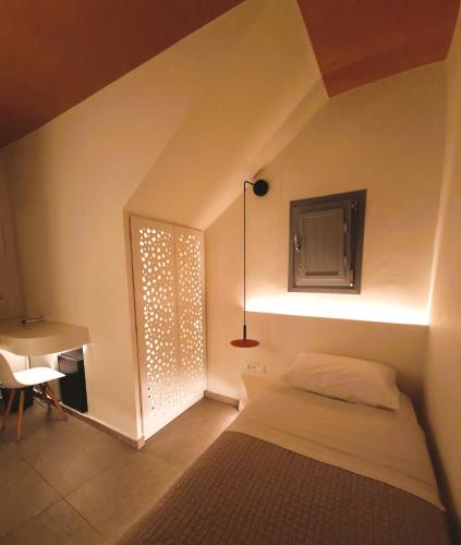 a bedroom with a bed and a desk and a window at Kykladonisia Traditional Settlement in Fira