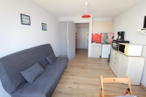 un salon avec un canapé et une cuisine dans l'établissement Grau du Roi studio cabine 4 personnes 300 m de la plage, au Grau-du-Roi