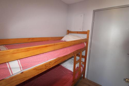 - 2 lits superposés dans une petite chambre avec une porte dans l'établissement Grau du Roi studio cabine 4 personnes 300 m de la plage, au Grau-du-Roi