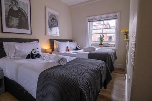 1 dormitorio con 2 camas con animales de peluche en Mayfair Shopping Retreat 2 Bedroom Luxury Apartment 8CB 4th floor without elevator en Londres