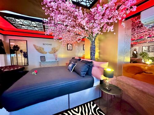 a bedroom with a bed and a tree with pink flowers at Beyond - Romantic Basement Apartment - Close To Beach - With Parking in Bournemouth