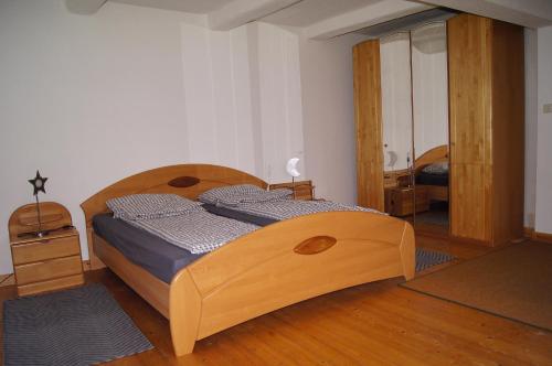 ein Schlafzimmer mit einem Holzbett in einem Zimmer in der Unterkunft Mitten im Garten in Friedland
