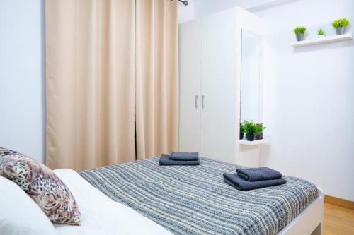 sypialnia z łóżkiem z niebieskimi ręcznikami w obiekcie Grandera Apart`s - Sollana 18 w Walencji