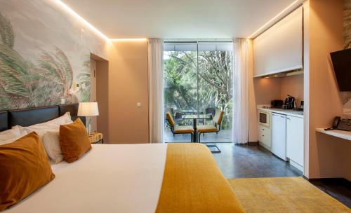 a bedroom with a bed and a kitchen with a table at Casa Vela Boutique House in Cascais