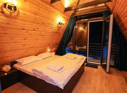 1 dormitorio con 1 cama en una cabaña de madera en Tramonto Cabin en Vartop