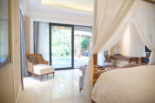 a bedroom with a bed and a living room at Wanda Reign Resort & Villas Sanya Haitang Bay in Sanya