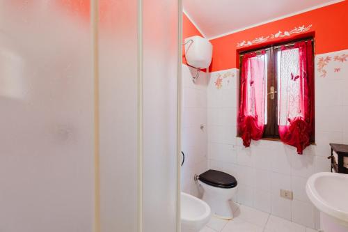 baño con aseo y ventana en Home Holidays Pintadera 2, en Bosa