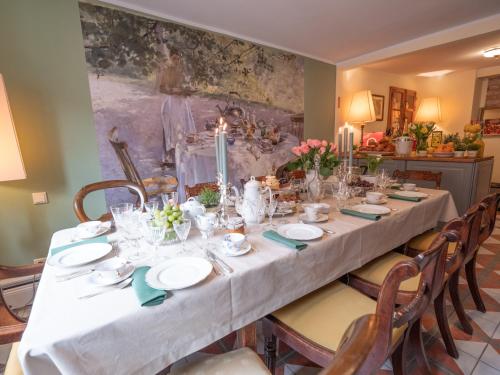 a long table with a white table cloth and candles at REFUGIUM Theresienstraße 19 - Chambre Monet in Rhodt unter Rietburg
