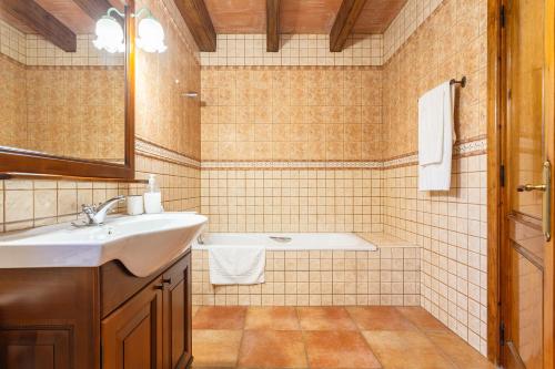 uma casa de banho com um lavatório e uma banheira em Can Malràs em Massanas