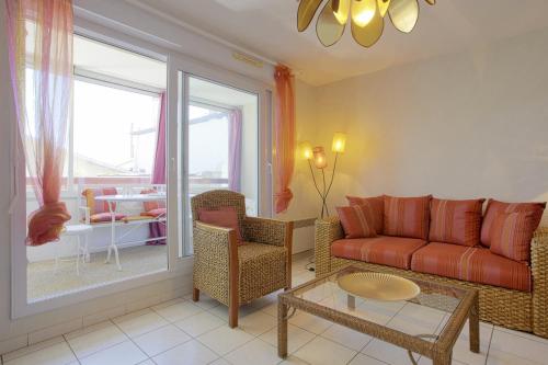 a living room with a couch and a table at Appartement Gabarra et sa loggia - Welkeys in Capbreton