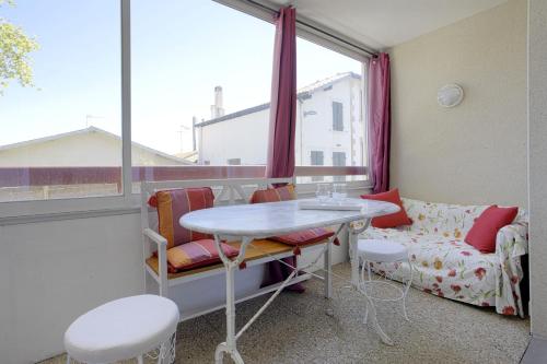 a room with a table and a couch and a window at Appartement Gabarra et sa loggia - Welkeys in Capbreton