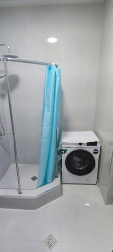 a washing machine with a blue curtain in a room at SABURTALO in Agaraki