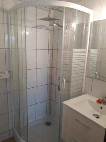 une salle de bain blanche avec une douche et un lavabo dans l'établissement APPARTEMENT CANET EN ROUSSILLON, à Canet