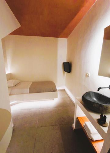 a bathroom with a bed and a sink in a room at Kykladonisia Traditional Settlement in Fira