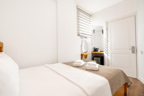 a white bedroom with a bed with towels on it at Audo Local in Antalya