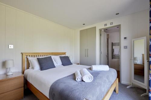 1 dormitorio con 1 cama grande y toallas. en Beckington Lodge en Beckington