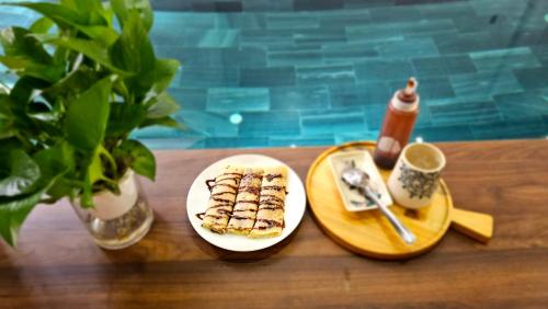 a table with two plates of food and a cup of coffee at Celia Boutique Hotel in Phong Nha