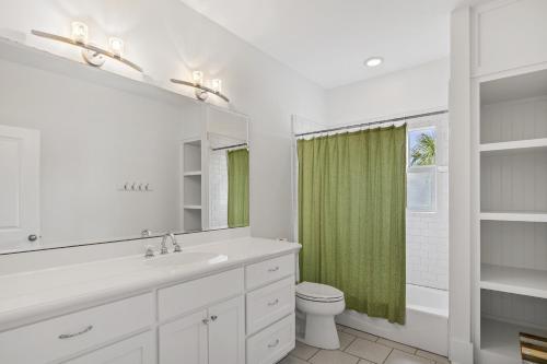 a bathroom with a sink and a toilet and a mirror at My Blue Heaven in Rosemary Beach