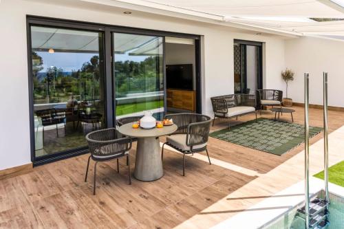 een huis met een patio met een tafel en stoelen bij Luxury Sea View Apartment by United Renters in Villajoyosa