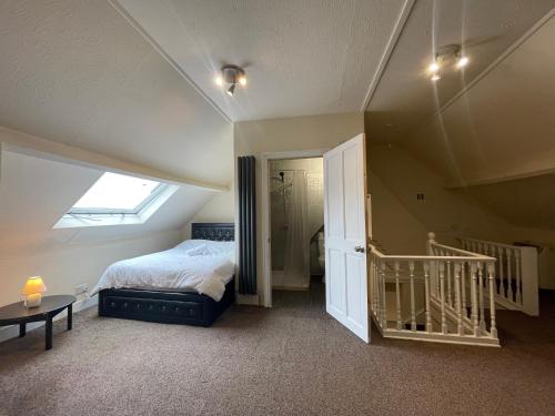 Room with private bathroom and shared kitchen في لندن: غرفة نوم بسرير ونافذة ودرج