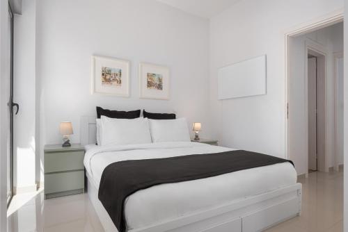 1 dormitorio blanco con 1 cama grande y 2 mesitas de noche en Varkiza Seaside Apartment, en Vari