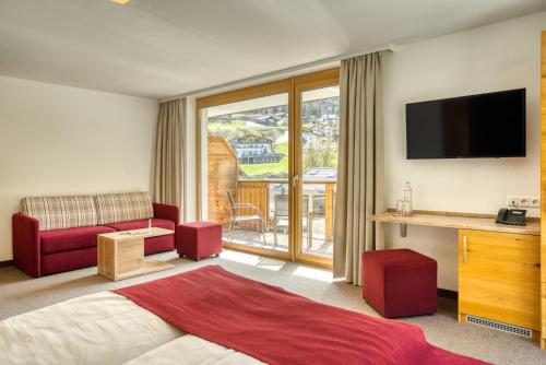 a hotel room with a bed and a television at Mallaun Hotel.Erlebnis in See