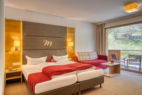 a hotel room with a bed and a couch at Mallaun Hotel.Erlebnis in See